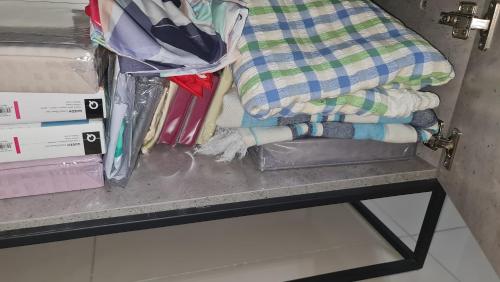 a shelf with towels and other items on a table at Te amo Gandaria Bangi Pool View Netflix Full Aircond in Bandar Baru Bangi