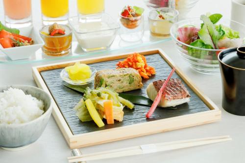 a plate of food with rice and vegetables on a table at IRAPH SUI, a Luxury Collection Hotel, Miyako Okinawa in Miyako Island