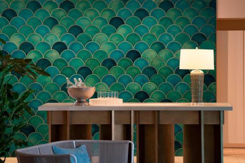 a table with a lamp and a green wall at IRAPH SUI, a Luxury Collection Hotel, Miyako Okinawa in Miyako Island