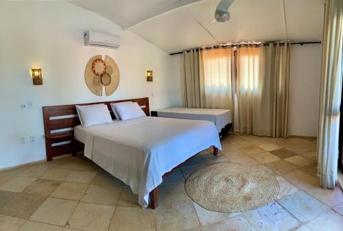 a bedroom with a large bed and a rug at Pousada Borboleta in Canoa Quebrada