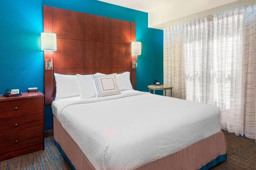 ein Schlafzimmer mit einem großen Bett und einer blauen Wand in der Unterkunft Residence Inn Tallahassee North I-10 Capital Circle in Tallahassee