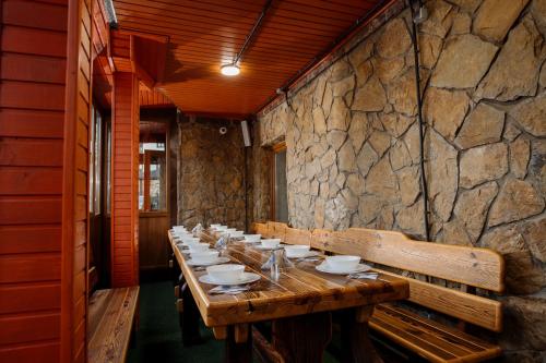a long wooden table in a room with a stone wall at Hotel Boutique Refael in Truskavets
