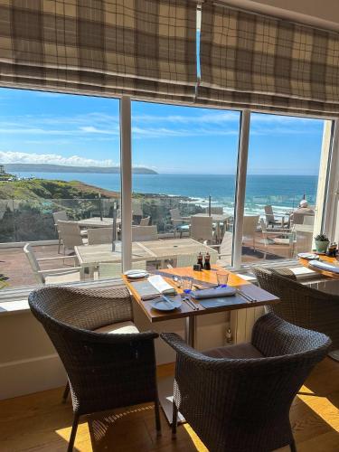 a dining room with a table and chairs and a large window at Watersmeet Hotel in Woolacombe
