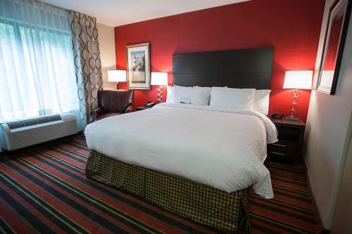 una camera d'albergo con un grande letto e pareti rosse di Fairfield Inn & Suites by Marriott Moscow a Moscow