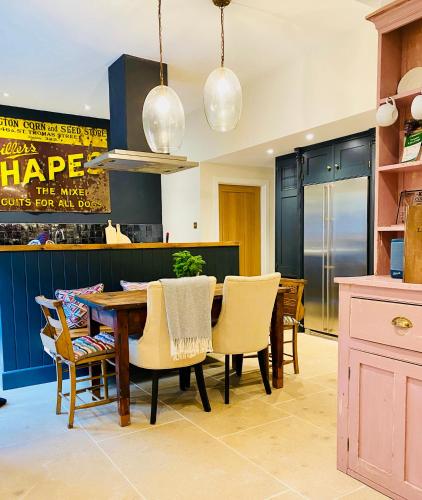 a dining room with a wooden table and chairs at Beautiful 3 bed cottage in Lymington. Perfectly located for Coast and New Forest in Lymington