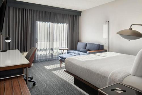 um quarto de hotel com uma cama, uma secretária e uma cadeira em Courtyard by Marriott Rye em Rye