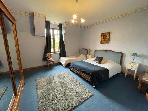 a bedroom with two beds and a rug at Le Château de Quinéville in Quinéville