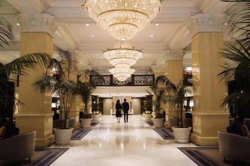 a couple walks through the lobby of a hotel at The US Grant, a Luxury Collection Hotel, San Diego in San Diego