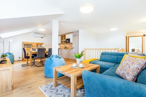 a living room with a blue couch and a table at KORZO LIPNO 2 in Lipno nad Vltavou