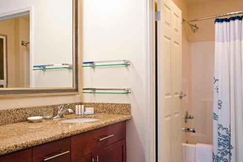 a bathroom with a sink and a mirror and a shower at Residence Inn Lansing West in Delta Center Township