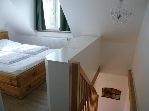 1 dormitorio con 1 cama y una escalera con una lámpara de araña. en Aloha 2, en Neue Tiefe Fehmarn