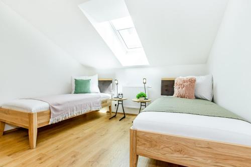 a bedroom with two beds and a skylight at KORZO LIPNO 2 in Lipno nad Vltavou