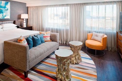 a hotel room with a bed and a couch and a chair at Dallas Marriott Suites Medical/Market Center in Dallas