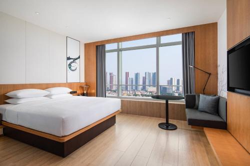 a hotel room with a bed and a large window at Fairfield by Marriott Foshan Nanhai in Foshan