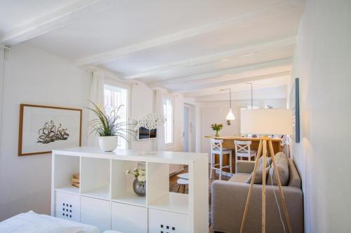 ein weißes Wohnzimmer mit einem Sofa und einem Tisch in der Unterkunft kleines Versteck- Ein ganz besonderes Domizil inmitten der Friedrichstraße in Westerland