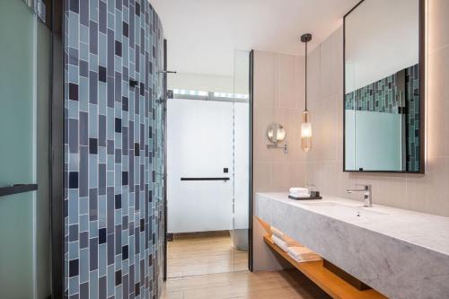 a bathroom with a large sink and a mirror at Fairfield by Marriott Foshan Nanhai in Foshan