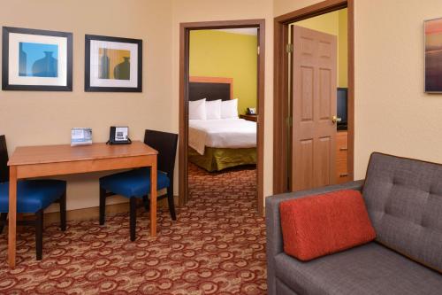 マイアミ・レイクスにあるTownePlace Suites Miami Lakesのデスクとベッドが備わるホテルルームです。