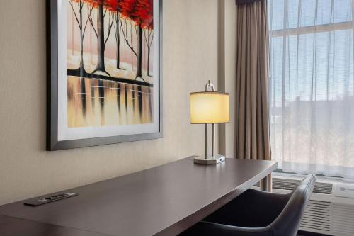 a desk in a hotel room with a lamp and a window at Delta Hotels by Marriott Somerset in Somerset