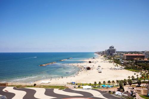 a view of a beach with people and the ocean at The Ritz-Carlton, Herzliya in Herzelia 