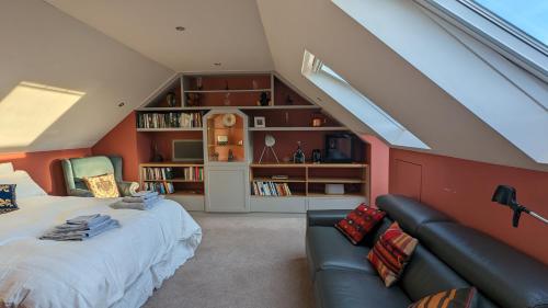 1 dormitorio en el ático con 1 cama y 1 sofá en Elegant Relaxed Studio, en Maynooth