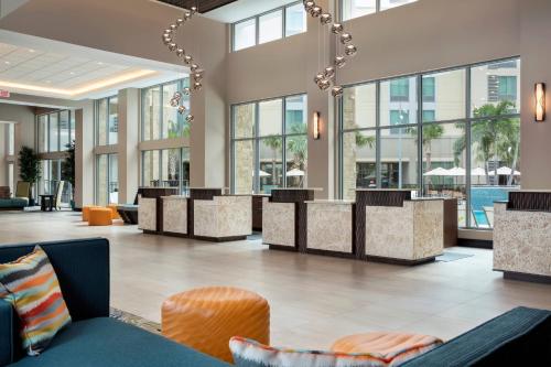 a lobby of a hotel with tables and chairs at TownePlace Suites by Marriott Orlando Theme Parks Lake Buena Vista in Orlando