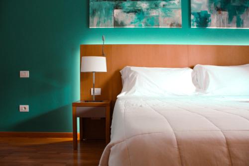 a bedroom with a bed and a table with a lamp at Principe Alogna Hotel & SPA in Altavilla Milicia