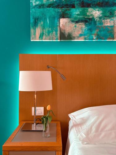 a bed room with a table with a lamp and a bed at Principe Alogna Hotel & SPA in Altavilla Milicia