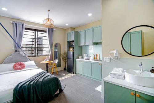 a bedroom with a bed and a sink and a mirror at SAZI BEN THANH Hotel HCM in Ho Chi Minh City