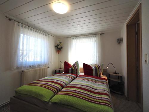 ツィングストにあるSchüler, Wolfgangのベッドルーム1室(大型ベッド1台、緑と赤の枕付)