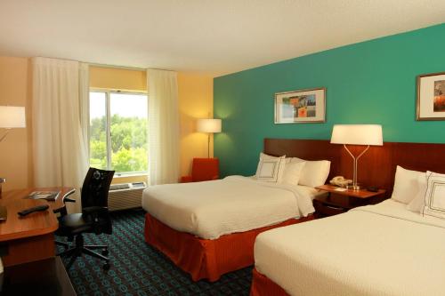 a hotel room with two beds and a desk at Fairfield Inn & Suites Traverse City in Traverse City