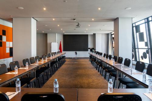 a conference room with tables and chairs and a chalkboard at ONOMO Hotel Casablanca City Center in Casablanca
