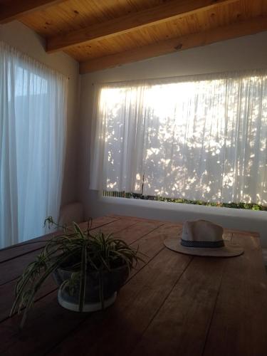 Habitación con ventana y sombrero en el suelo de madera. en Hospedaje La Calma en San Miguel del Monte