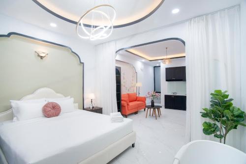 a white bedroom with a bed and a living room at SAZI BEN THANH Hotel HCM in Ho Chi Minh City
