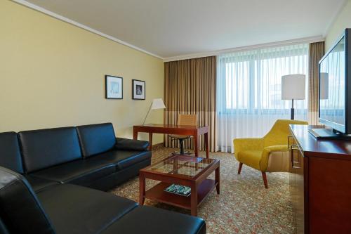 a living room with a couch and a table at Courtyard by Marriott Düsseldorf Seestern in Düsseldorf