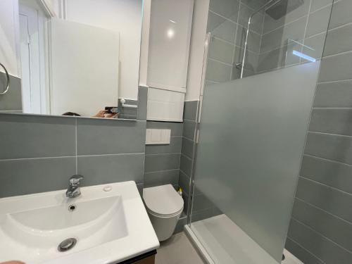 une salle de bain avec un lavabo, des toilettes et une douche dans l'établissement Les Geraniums, à Nice