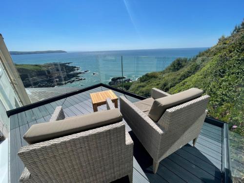 two chairs and a table on a balcony with the ocean at Watersmeet Hotel in Woolacombe