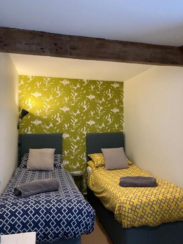 dos camas sentadas una al lado de la otra en una habitación en Elishaw Farm Holiday Cottages, en Otterburn