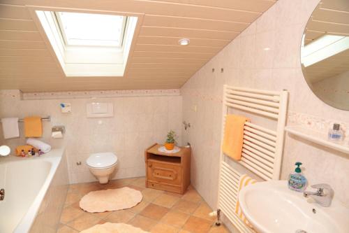 a bathroom with a sink and a tub and a toilet at Landgasthof Zum Sägwirt in Eggstätt
