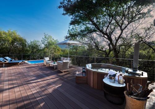a deck with a hot tub and a hot tub at Babohi at Qwabi Private Game Reserve by NEWMARK in Bela-Bela