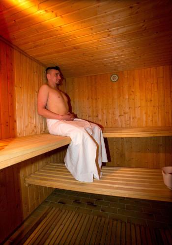 a man is sitting in a sauna at Pension Arberwald in Bayerisch Eisenstein
