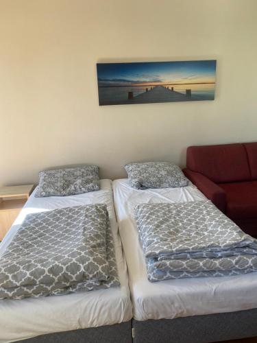 2 camas individuales en una habitación con sofá en Apartament Feniks - blisko morza en Świnoujście