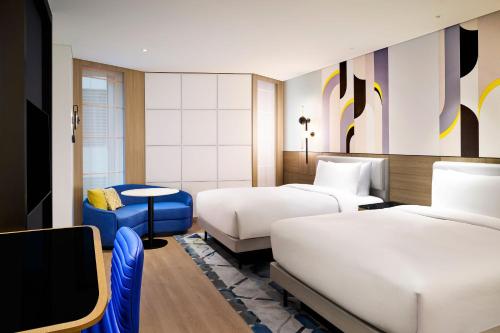 a hotel room with two beds and a tv at Le Meridien Seoul Myeongdong in Seoul