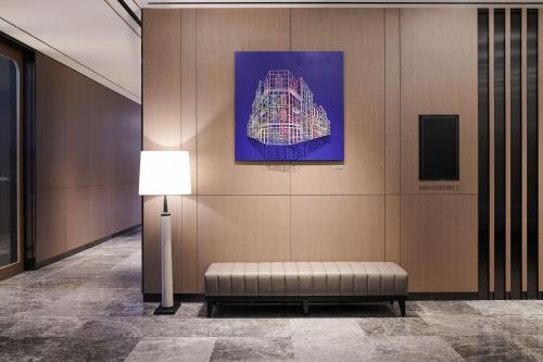 a waiting room with a bench and a painting on the wall at Le Meridien Seoul Myeongdong in Seoul