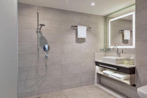 a bathroom with a shower and a sink at Courtyard by Marriott Oberpfaffenhofen Munich South in Gilching