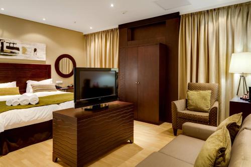 a hotel room with a bed and a flat screen tv at Protea Hotel by Marriott Transit O.R. Tambo Airport in Kempton Park