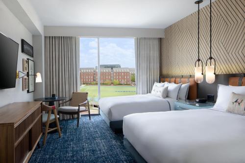 a hotel room with two beds and a desk at The Ellison, Oklahoma City, a Tribute Portfolio Hotel in Oklahoma City