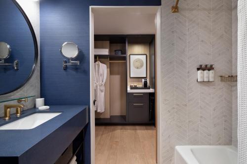uma casa de banho com um lavatório e um espelho em The Ellison, Oklahoma City, a Tribute Portfolio Hotel em Oklahoma City