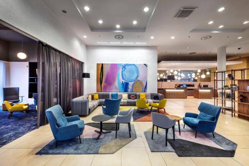 eine Lobby mit einem Wohnzimmer mit Sofa und Stühlen in der Unterkunft Courtyard by Marriott Prague Airport in Prag