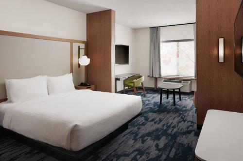 Habitación de hotel con cama y escritorio en Fairfield Inn & Suites Louisville New Albany IN en New Albany