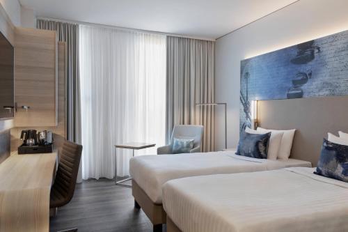 een hotelkamer met 2 bedden en een bureau bij Courtyard by Marriott Munich Garching in Garching bei München